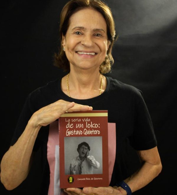 Fotografía de Consuelo de Quintero sosteniendo el libro: La seria vida de un loko: Gustavo Quintero