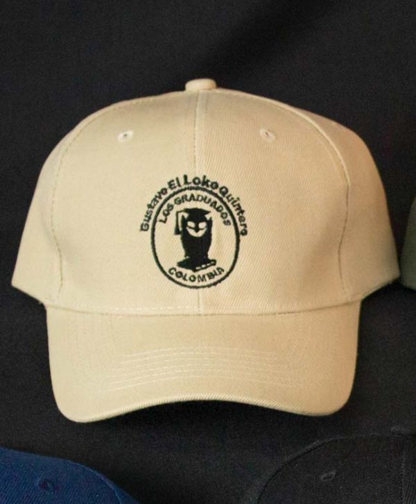 Gorra con el logo estampado de la Orquesta Los Graduados de Gustavo "Loko" Quintero. Color beige.